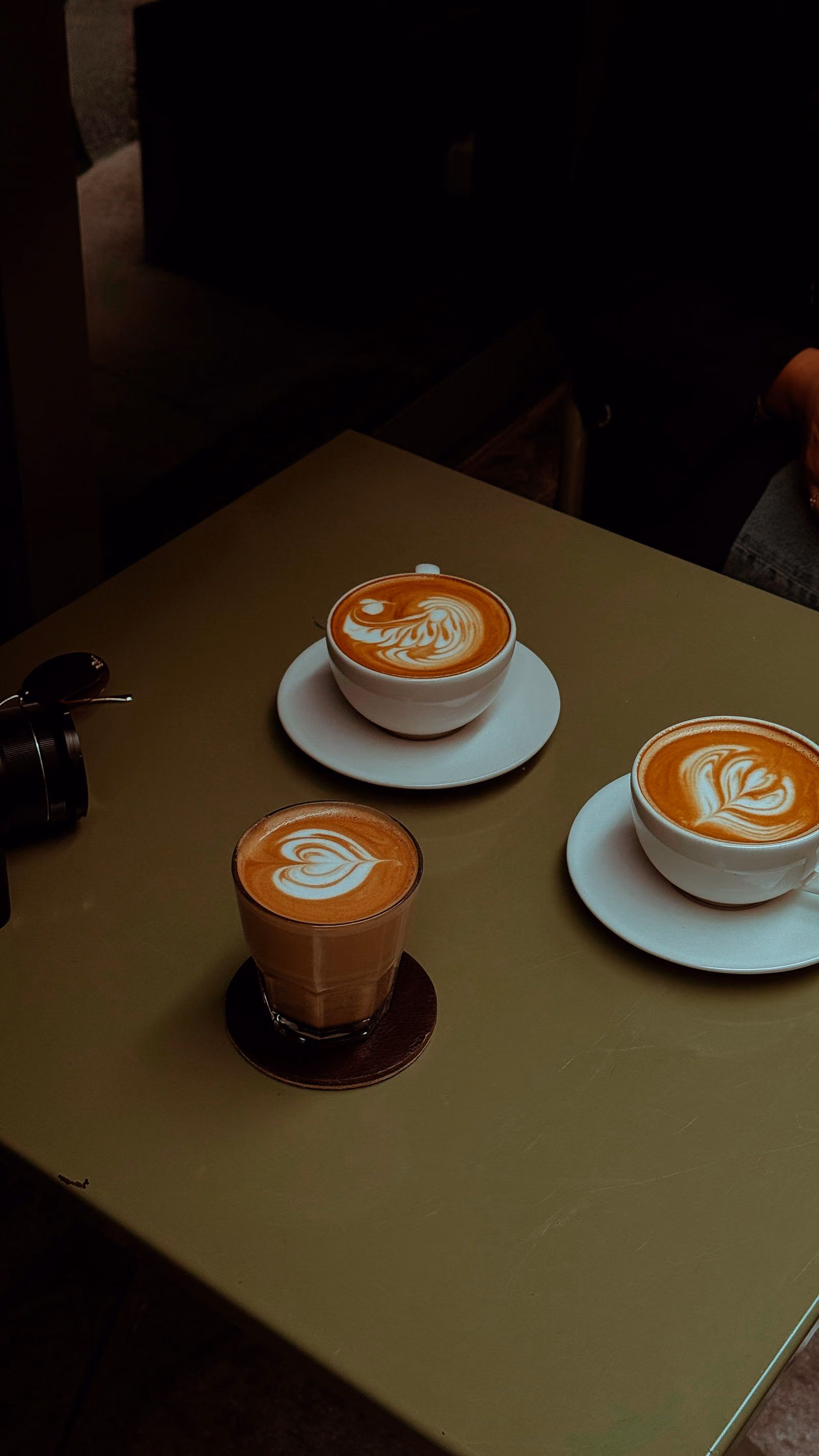 Taza de café con latte art sobre una mesa de madera